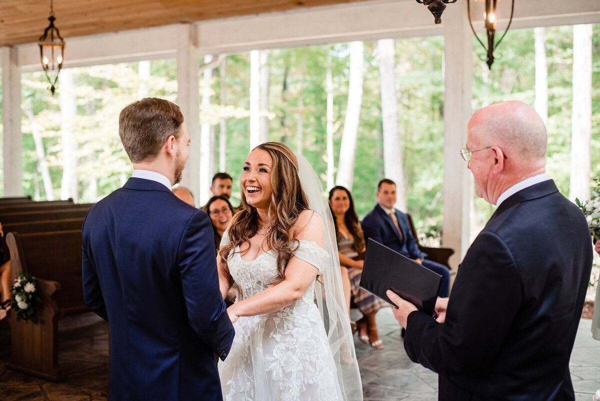 Bride laughing and smiling at groom during ceremony