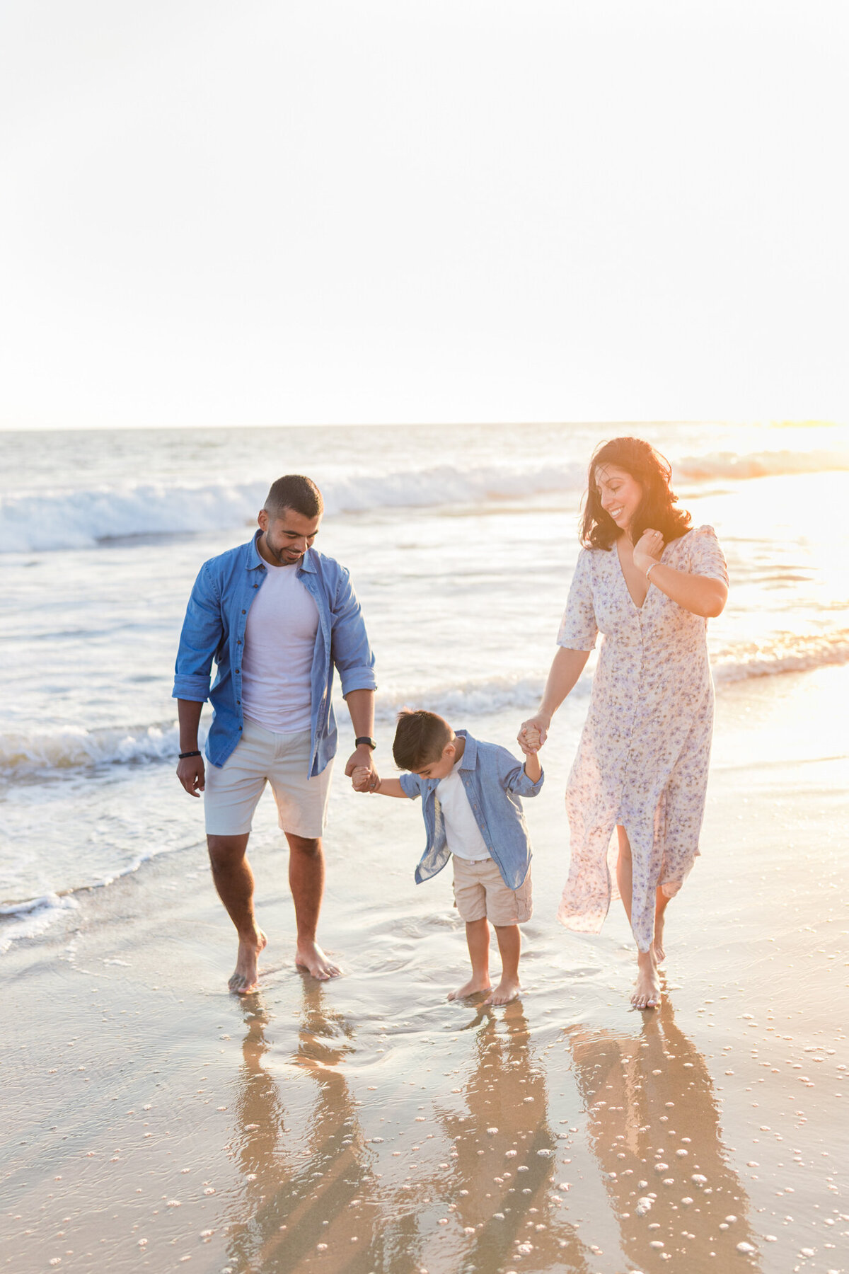 family walking on the beach at sunset