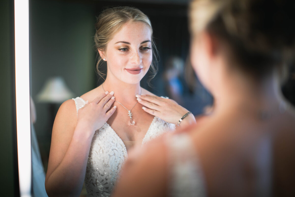 woman looking at wedding dress in mirror
