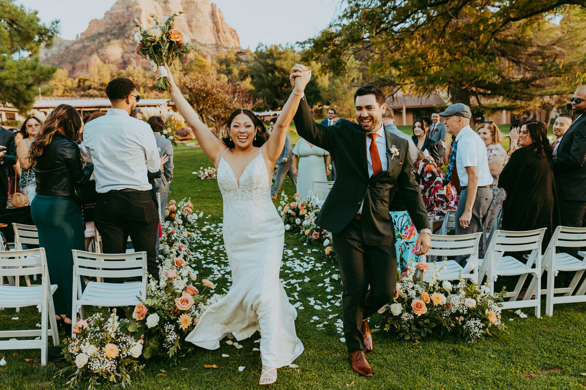 wedding couple smiles as they walk down isle at poco diablo resort in sedona