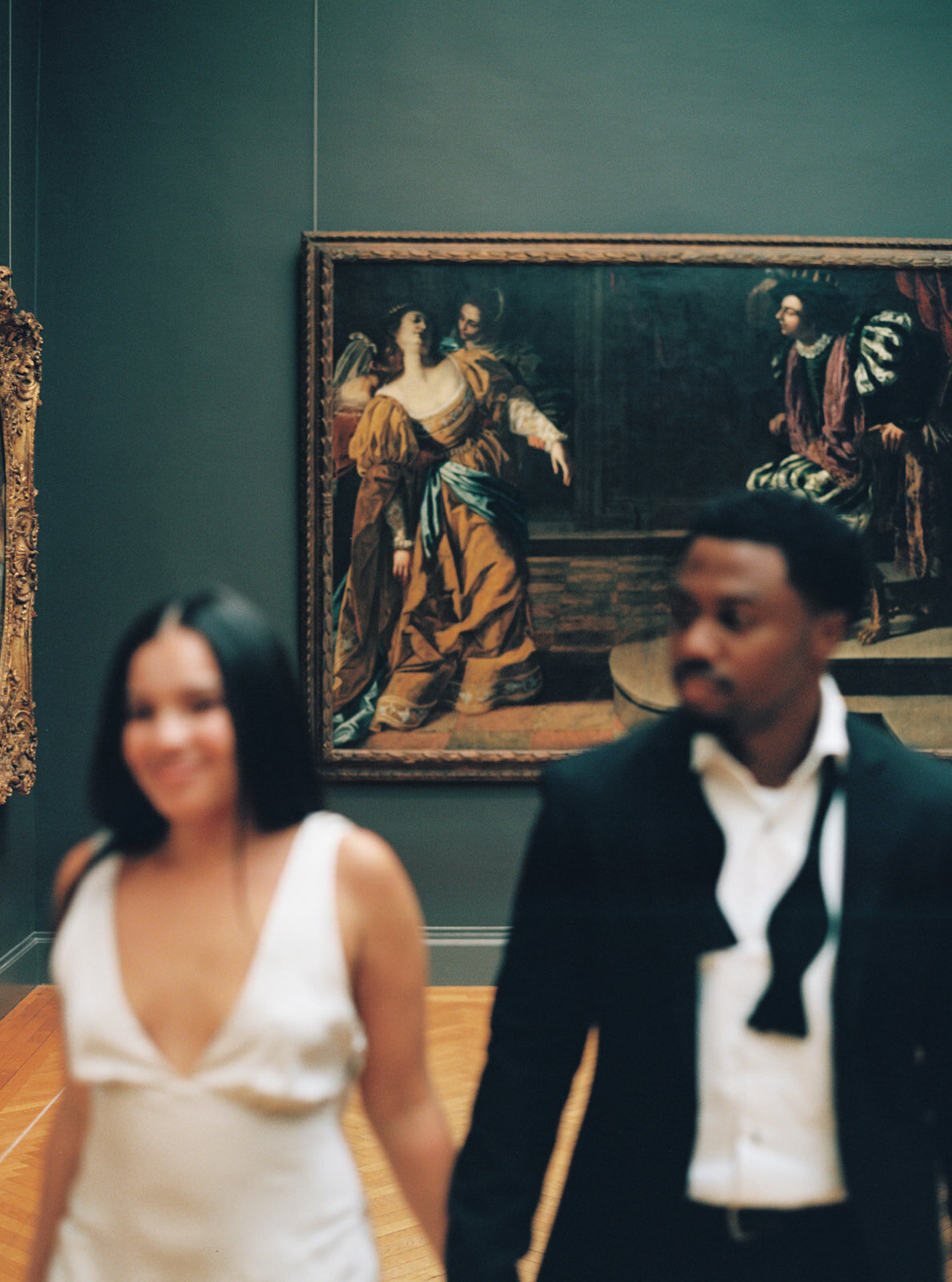 couple walking past with artwork in focus behind them