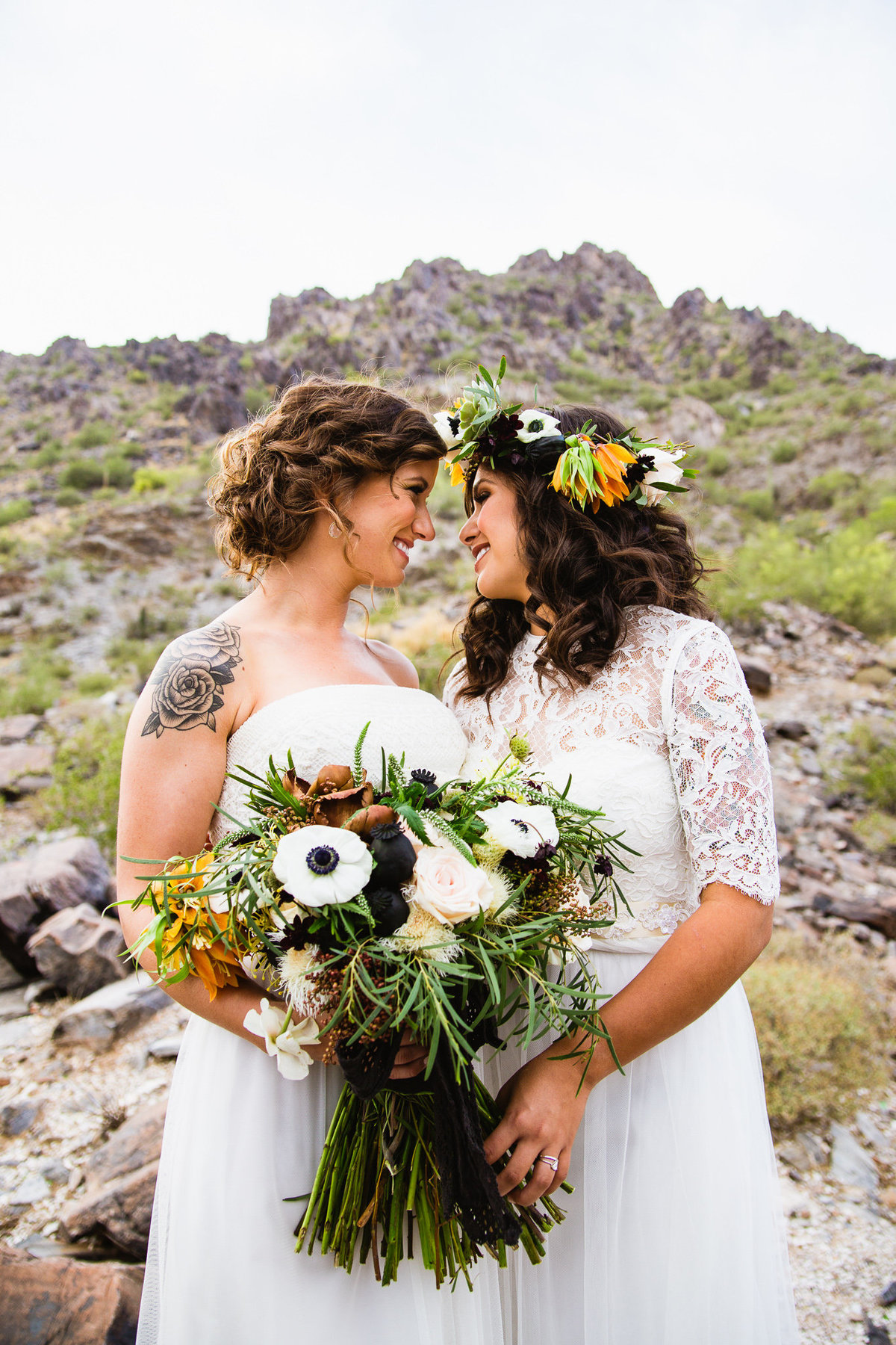 LGBT couple look at each other in the Arizona desert by Phoenix wedding photographer PMA Photography.