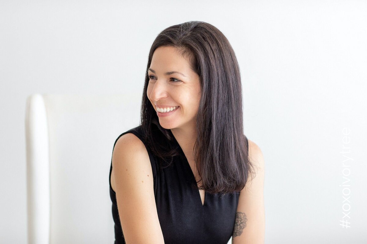 Corporate headshot of a woman with sleek straight hair and neutral tones