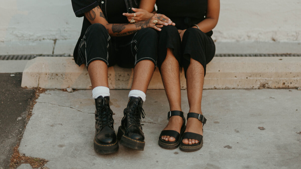 portrait of a tattooed couple sitting together, holding hands 