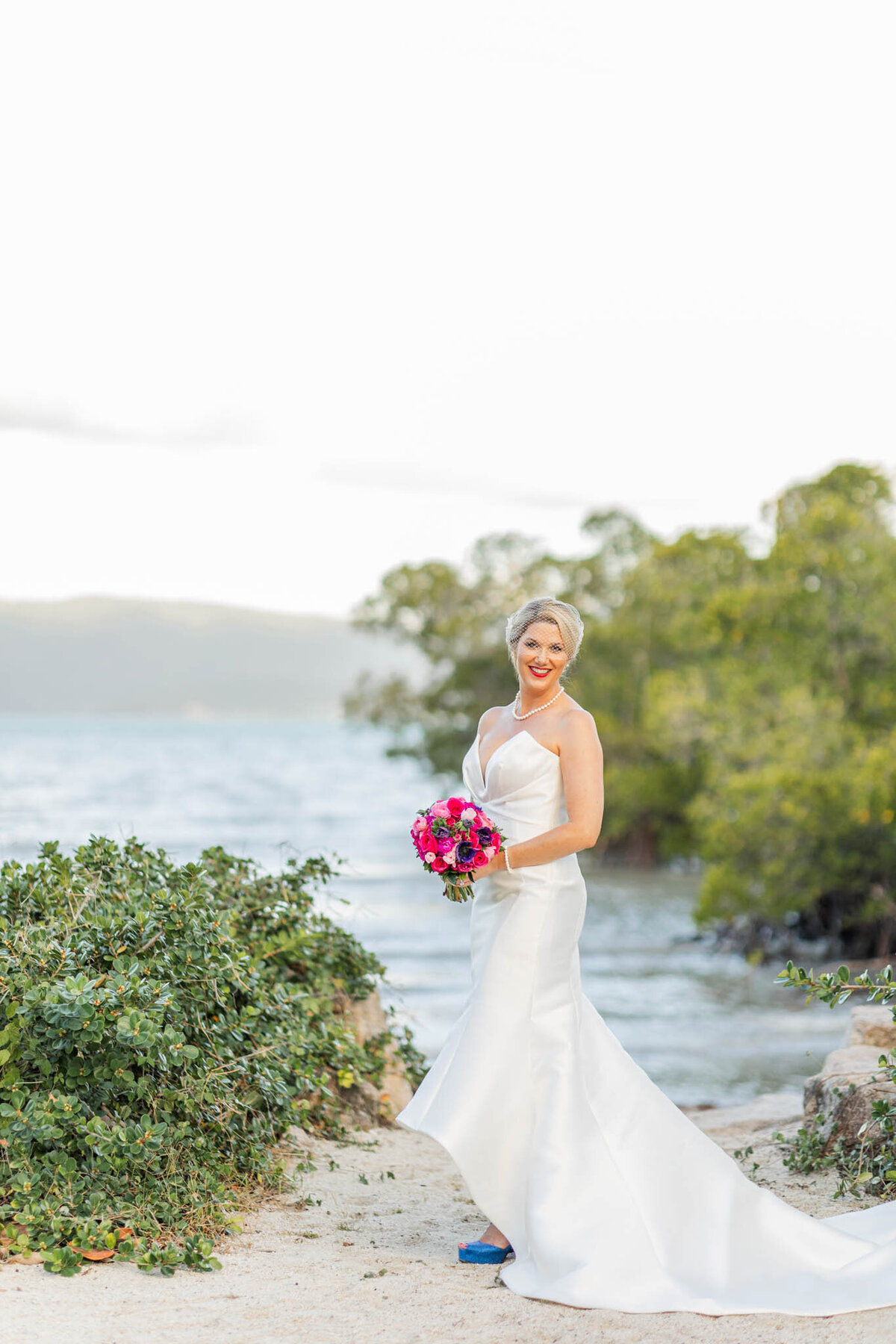 Beautiful bride stands for bridal portraits with the beautiful Whitsunday waters in the background