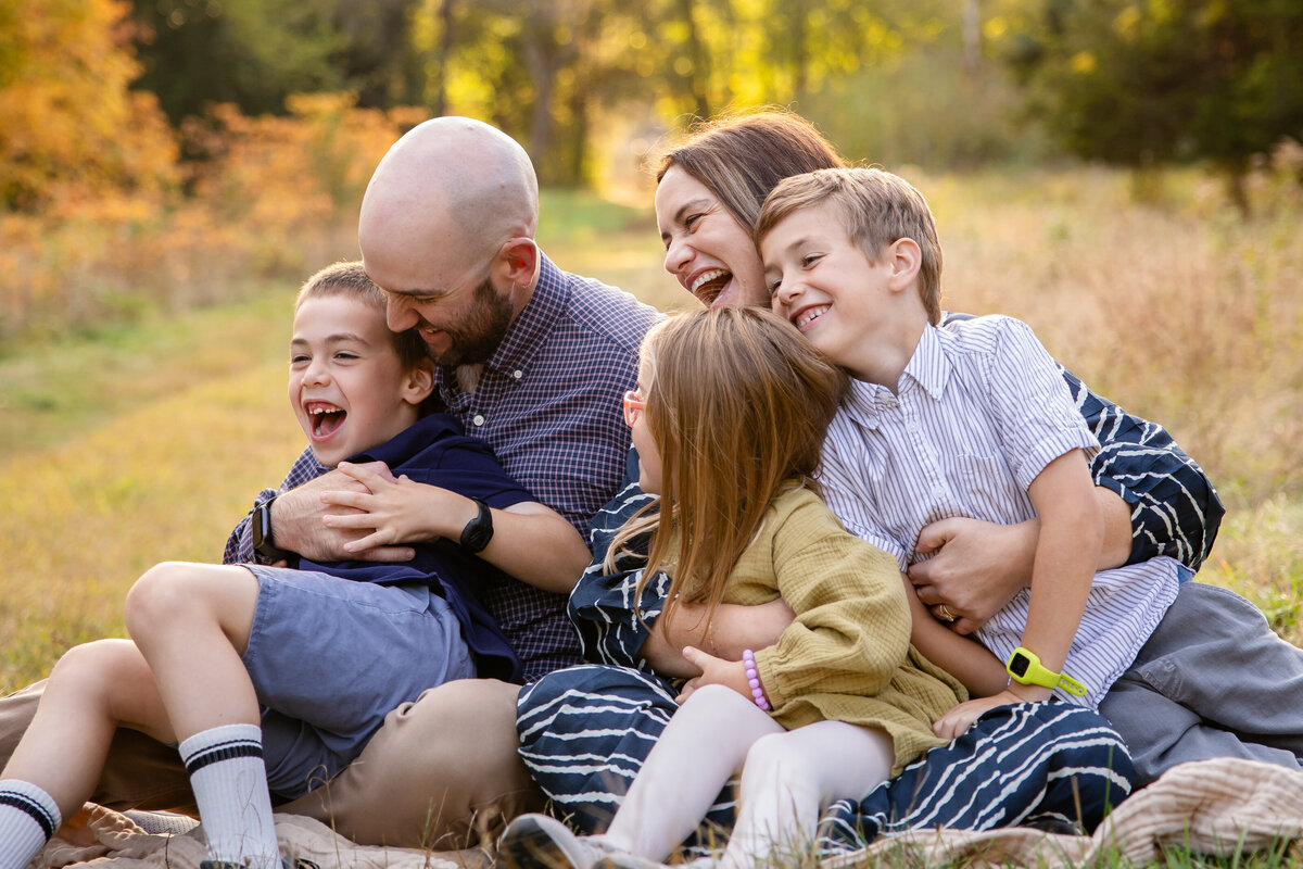 Family of five snuggling and laughing during family photos