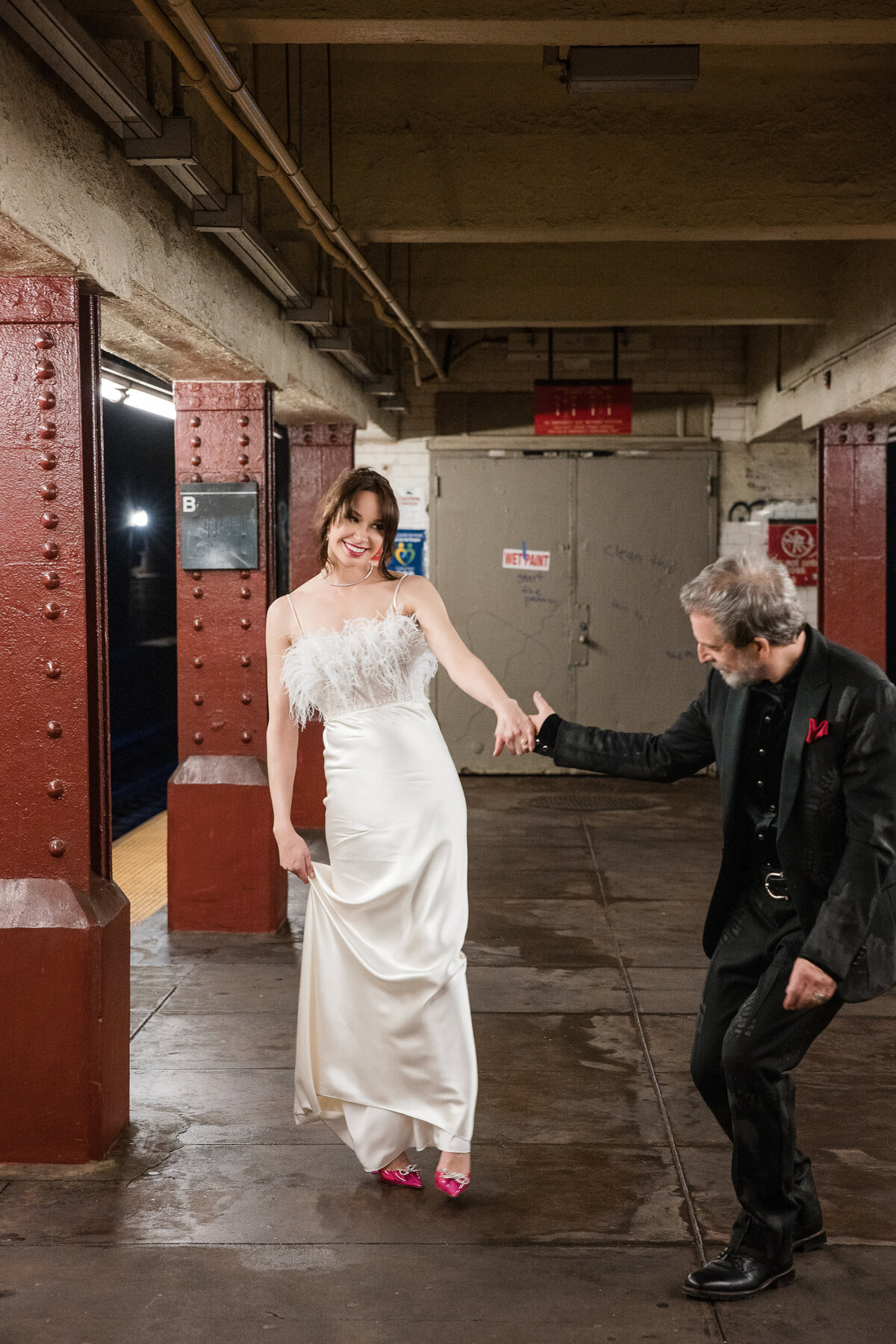 A wedding couple take photos on a subway platform in Manhattan