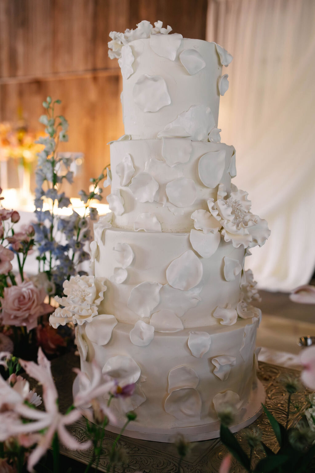 Elegant white tiered wedding cake with sculpted sugar petals displayed at The Bascom Center fall wedding in Highlands NC.