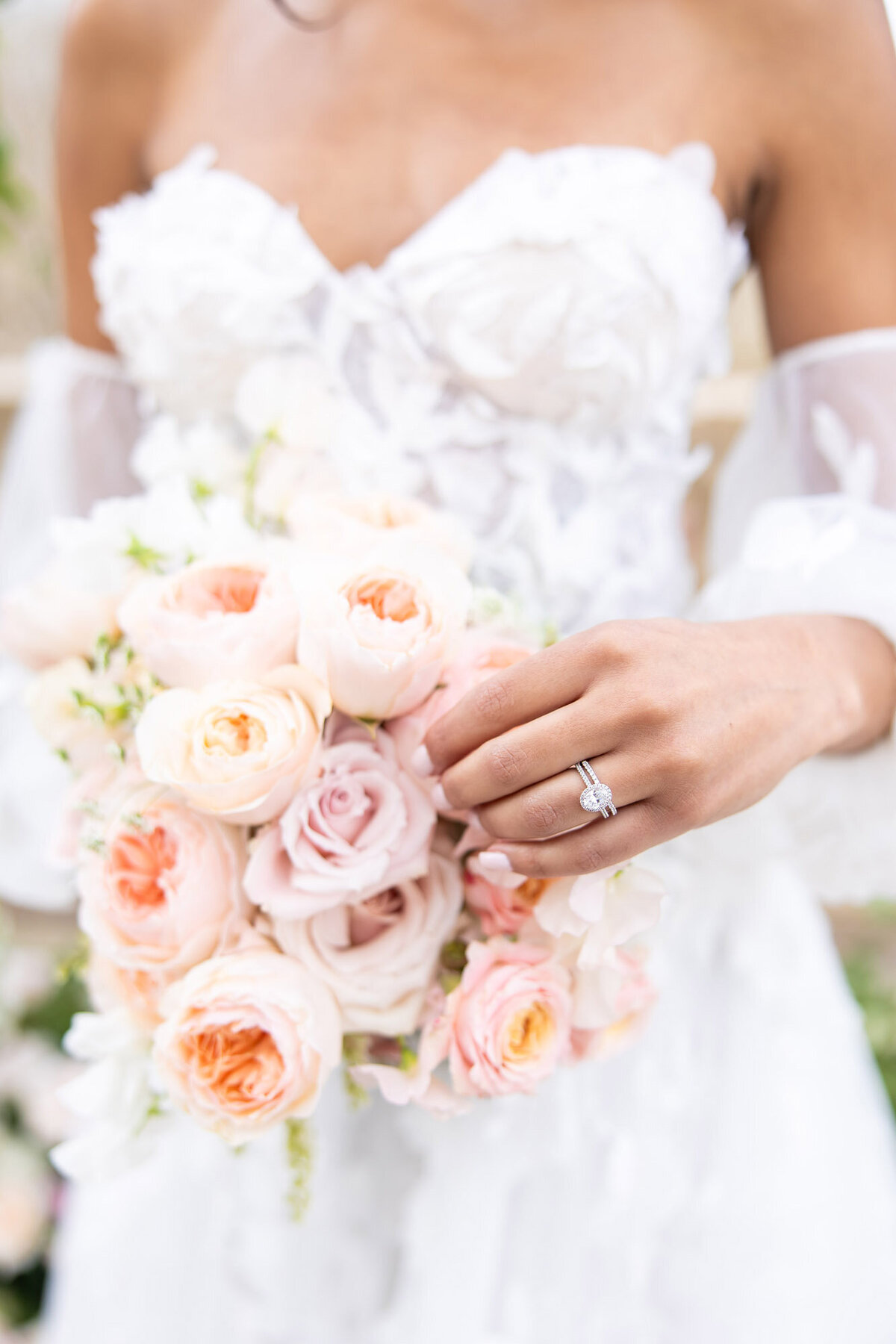 Bride gently touching a rose on her bridal bouquet