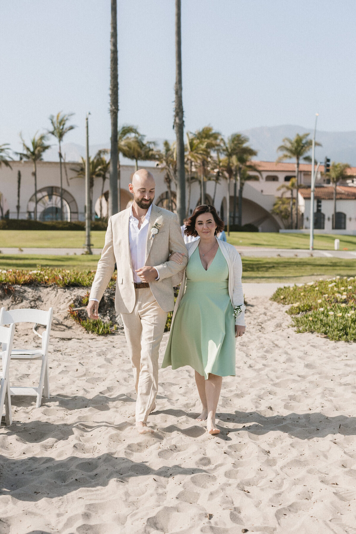 Groom and mom walking down aisle on beach at ceremony at Hilton Beachfront Resort Santa Barbara
