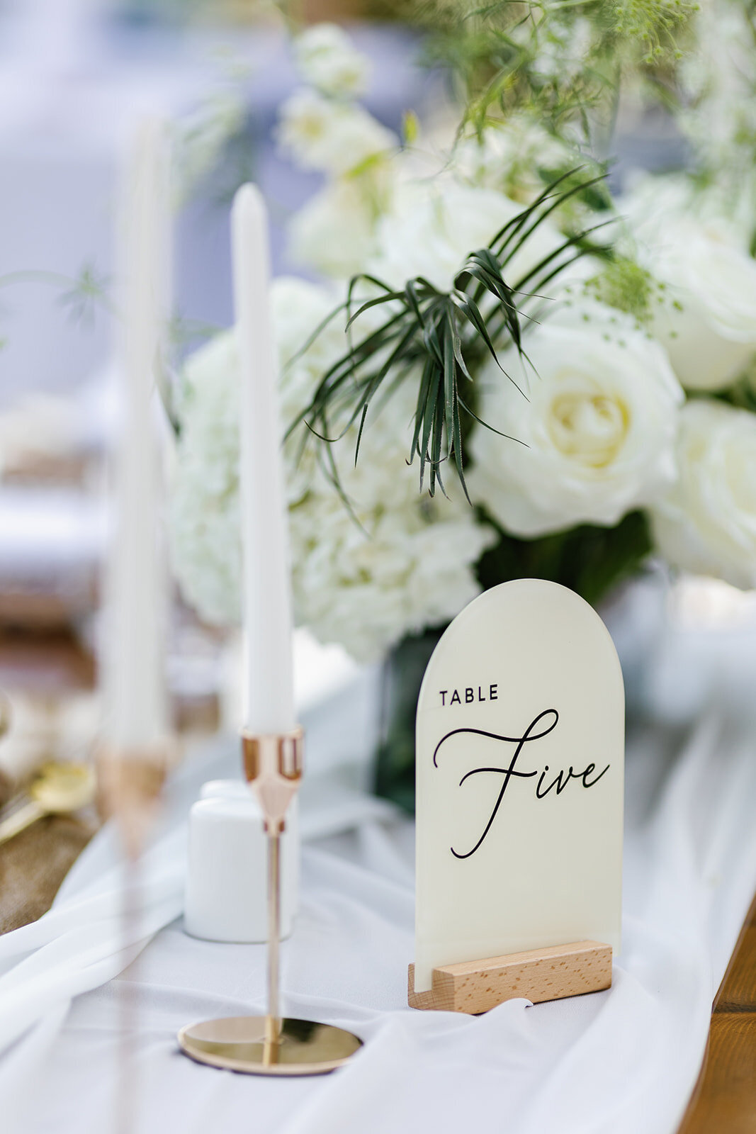 Elegant wedding reception decor with white roses and greenery at La Siesta Marina.