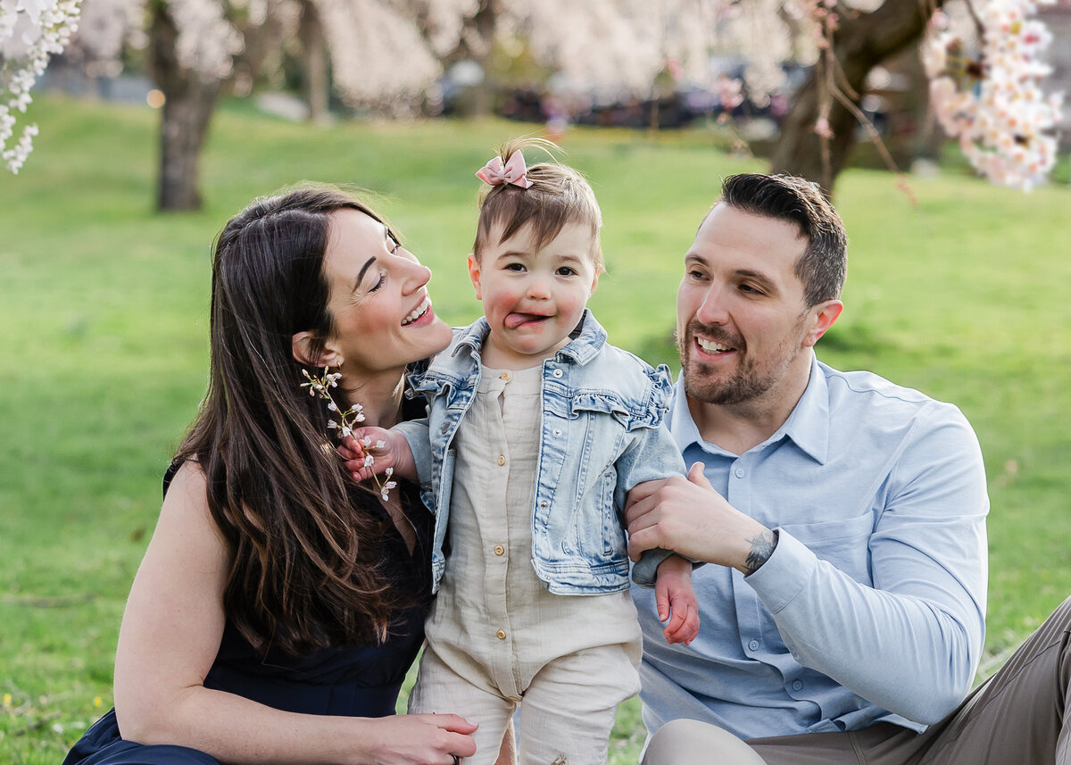 Goofy lifestyle photo of family hugging and smiling at an Essex County, New Jersey park.