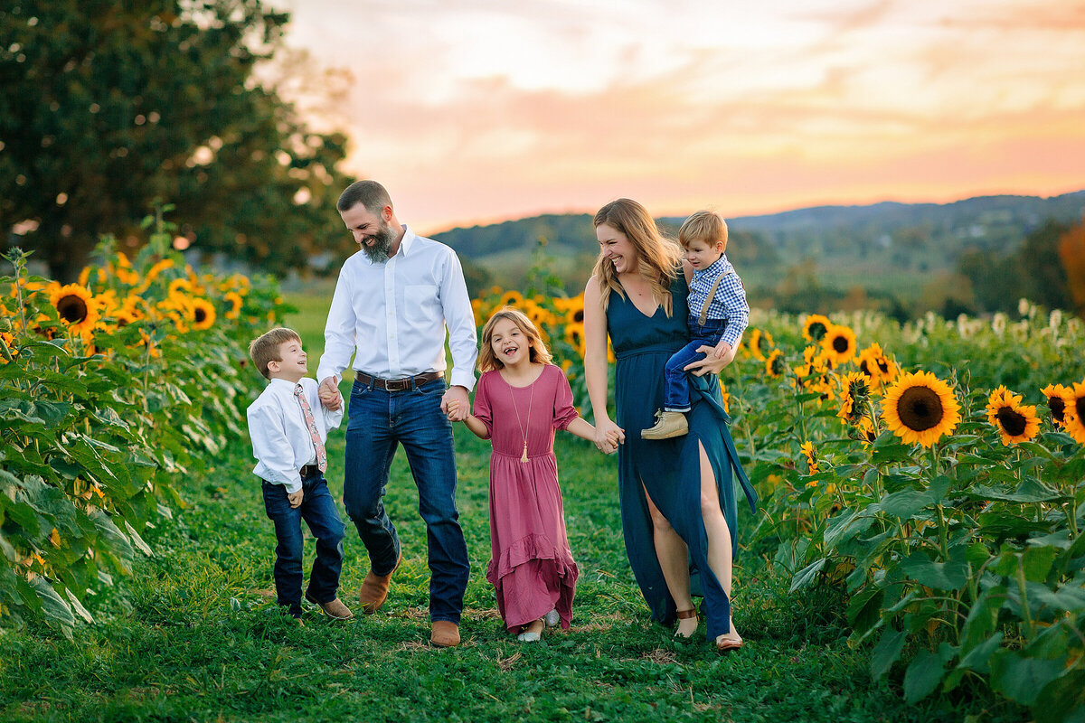 Family walking through sunflower field in Harrisonburg, VA