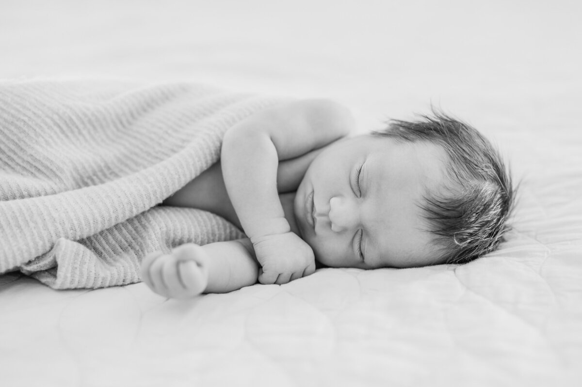 Black and white in-home newborn portrait of a sleeping baby.