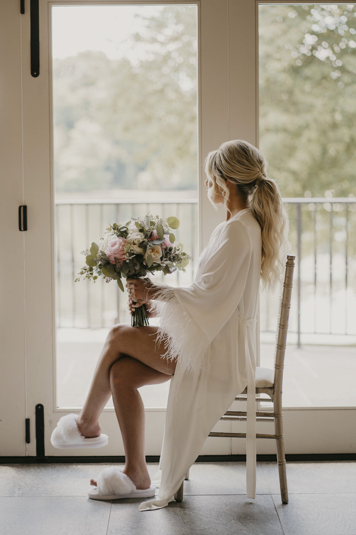 Bride in a white robe with her flowers
