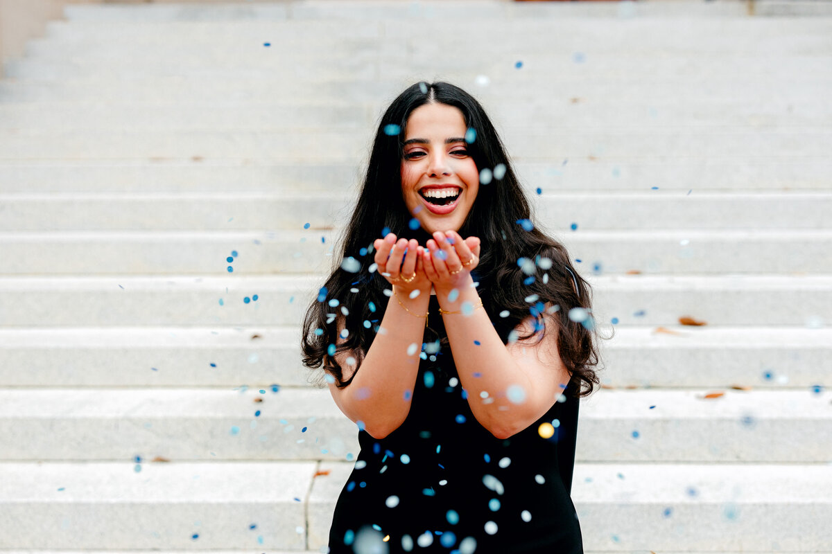 Graduate celebrating with confetti during a portrait session by Anh Nguyen, NYC-based photographer.