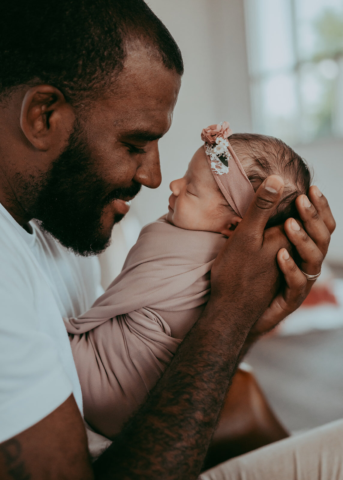 dad sits face to face with his tiny newborn baby girl