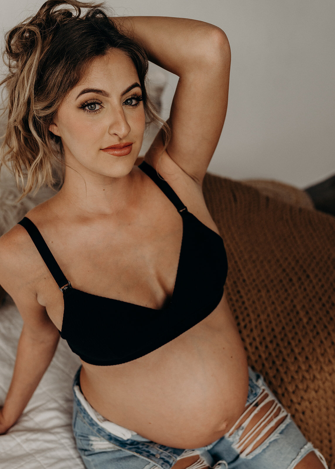 glamour image of pregnant woman in bra and jeans