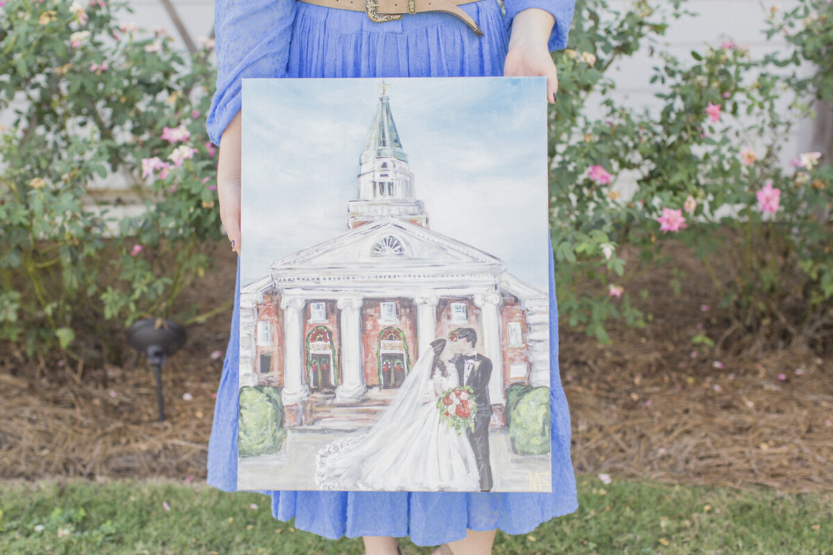 Miriam holding a live wedding painting finished product.