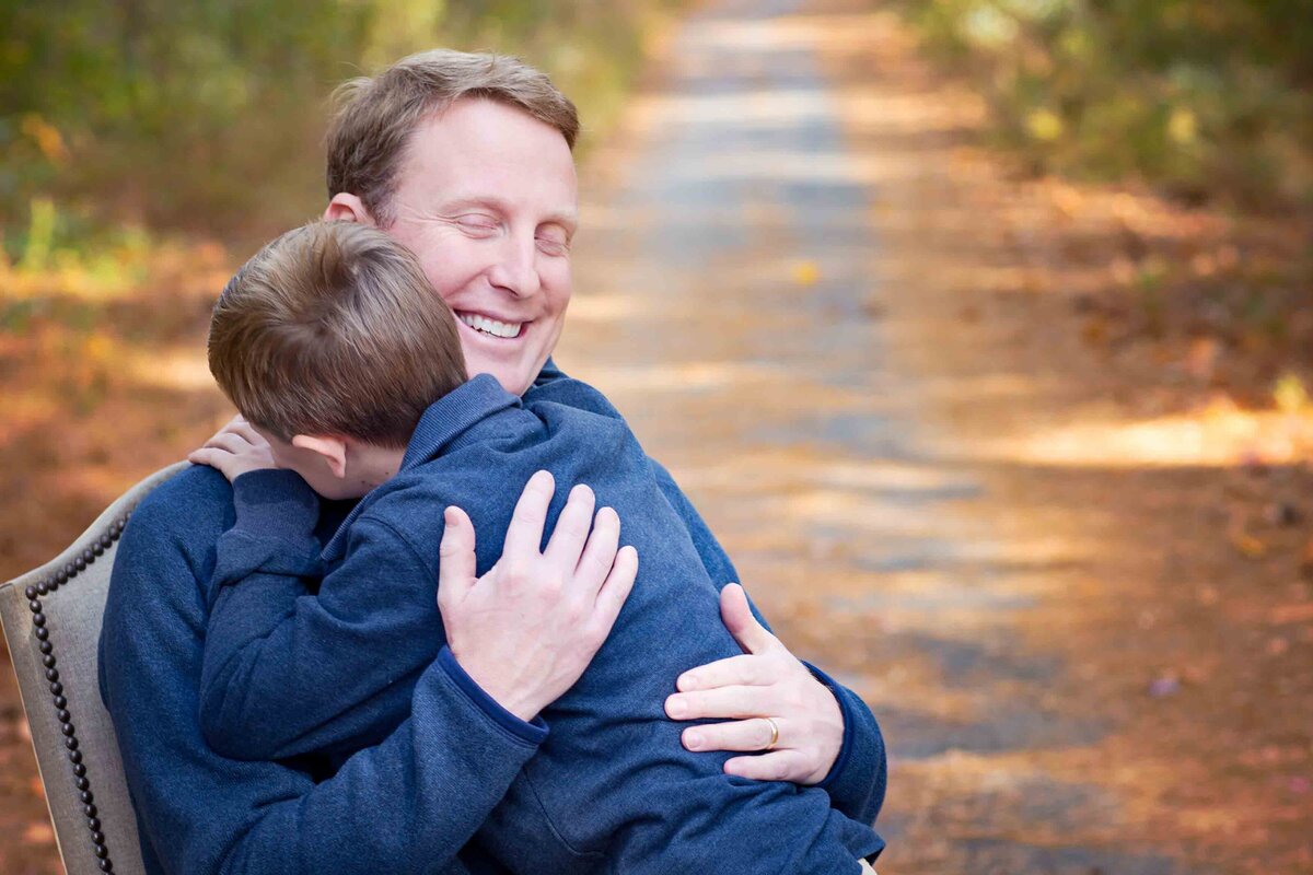 Father getting a big  hug from his son.