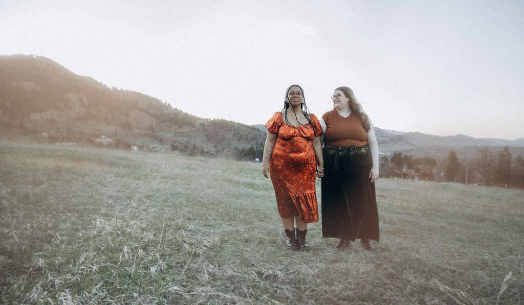 A couple walking in a field together.