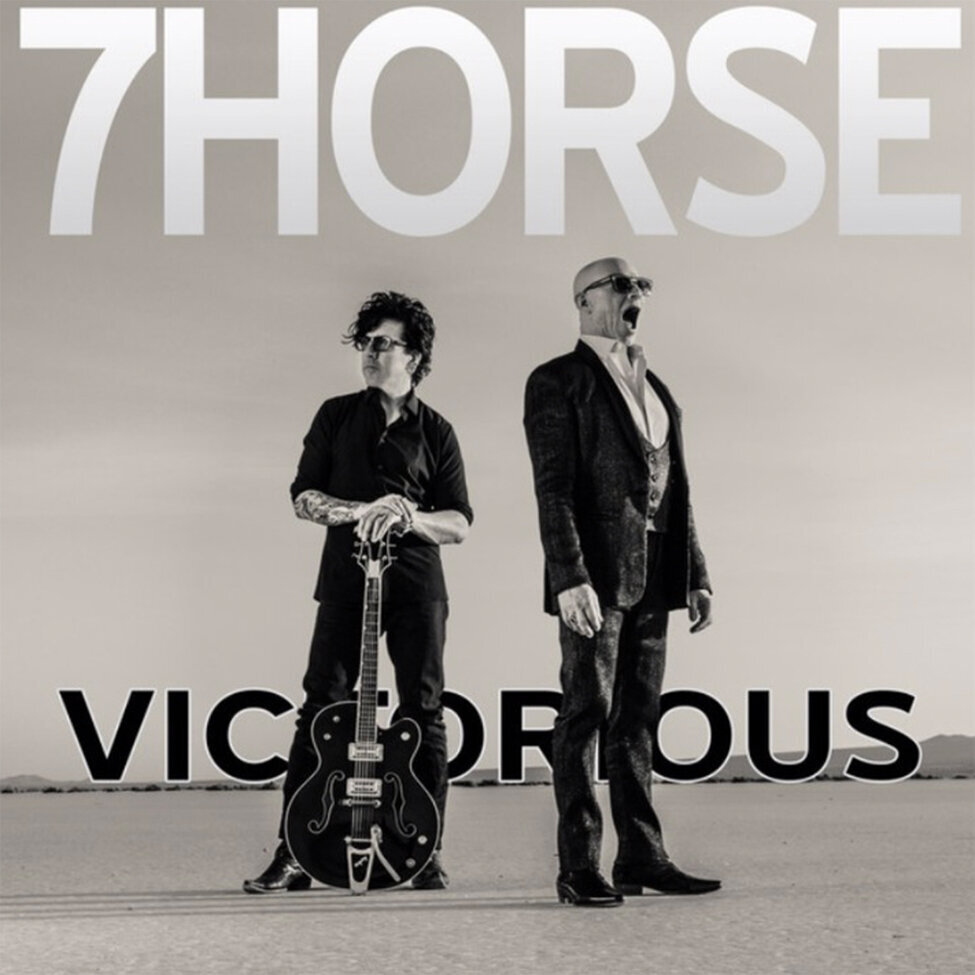 Single Cover 7horse band Victorious black and white duo standing in desert singer with mouth open band mate holding neck of guitar standing upright on sand between his legs