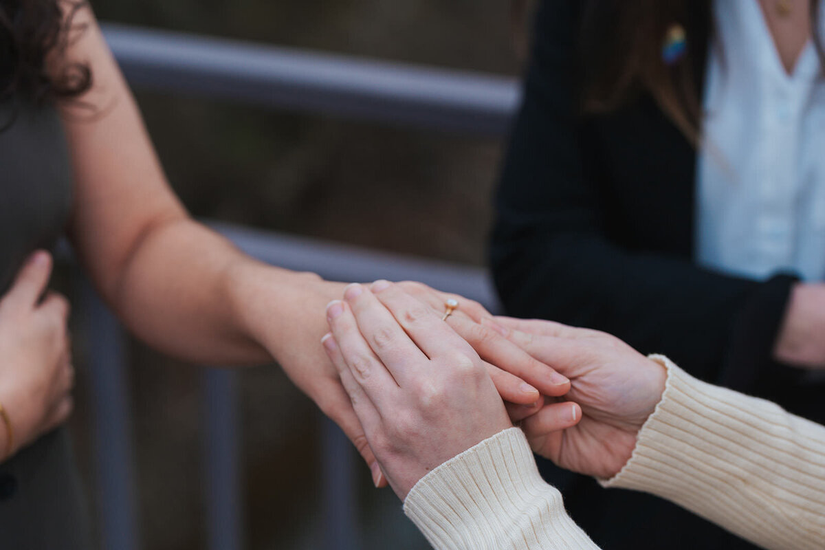 Wife puts her wife's wedding ring on 