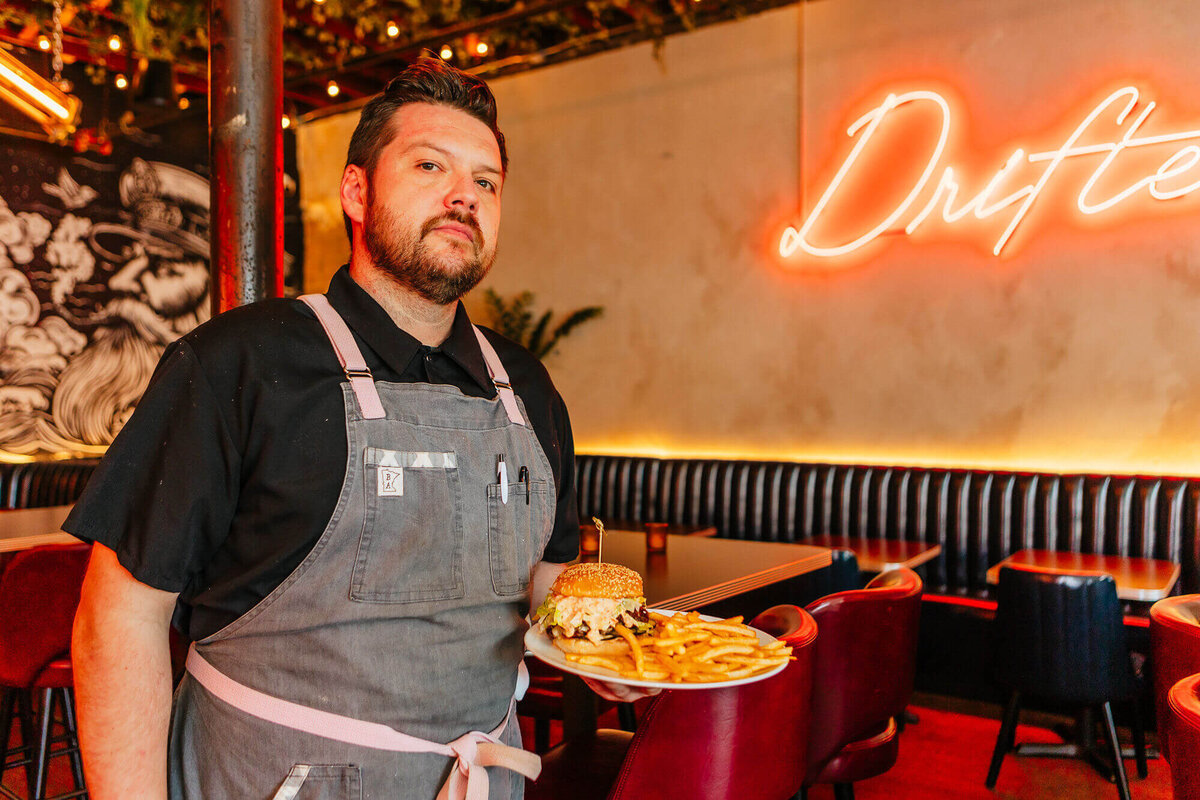 drifter's server bringing a smash burger and fries