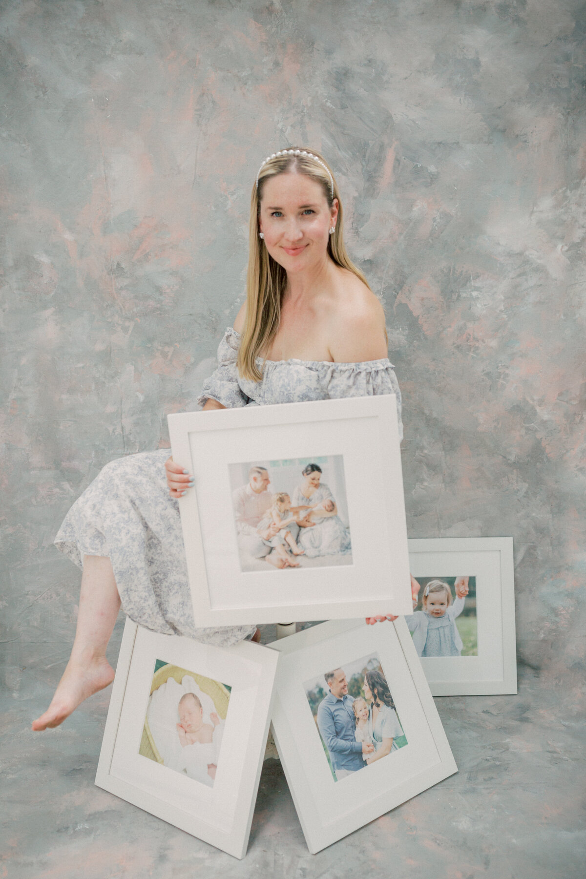 Marie Elizabeth Photography sits with fine art framed and matted prints in her studio