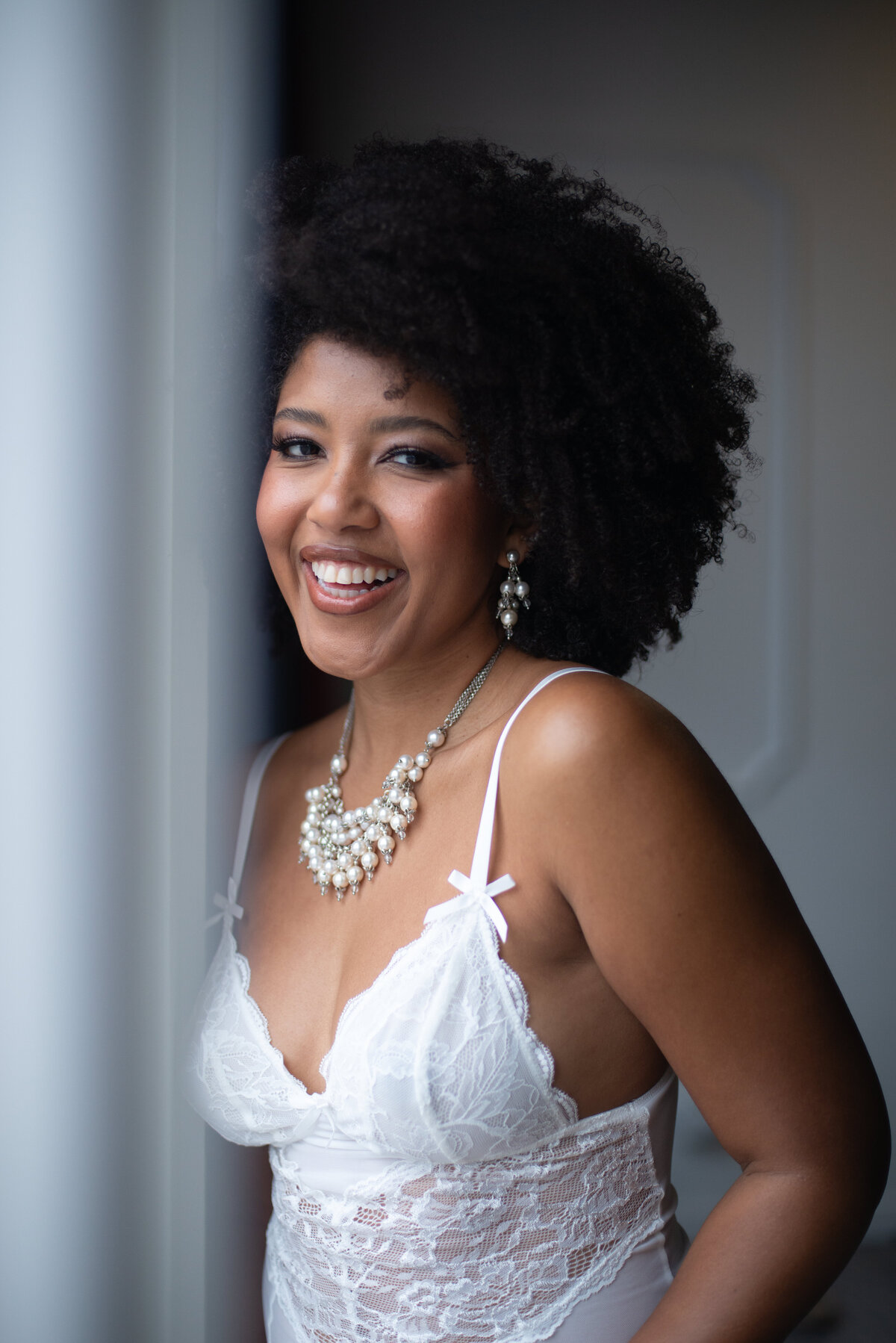 Classy boudoir portrait of a woman in elegant white attire