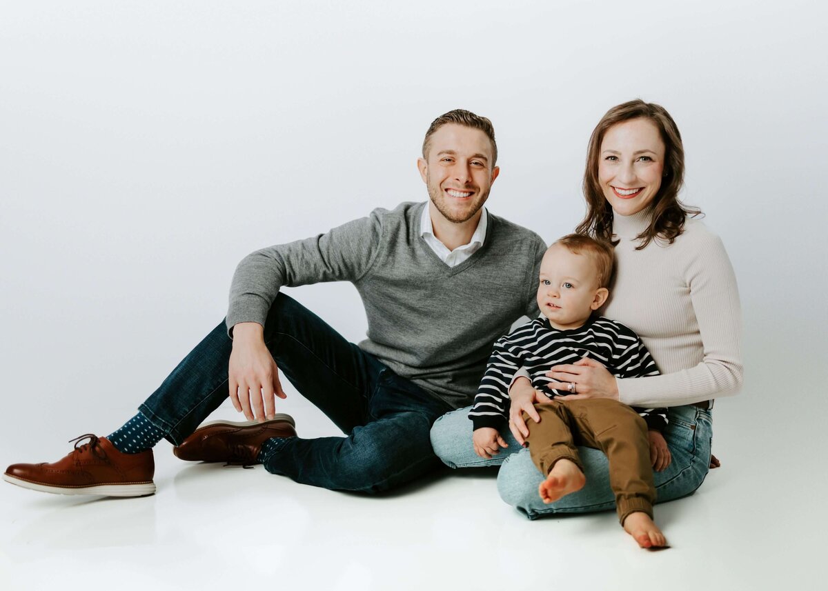 A Pittsburgh family photographer captures the family posing on the floor for a photo.