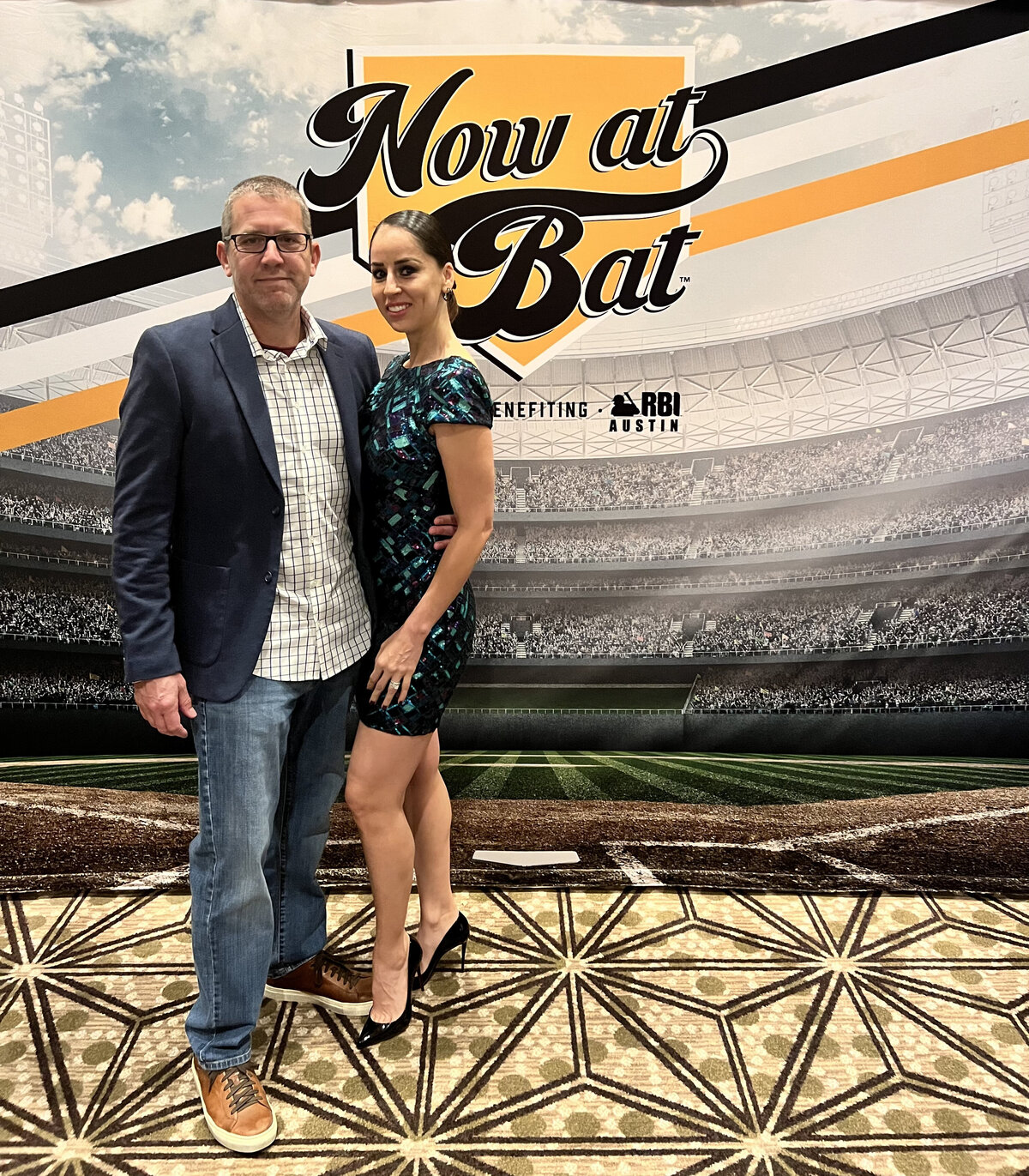 Couple posing in front of RBI gala sign
