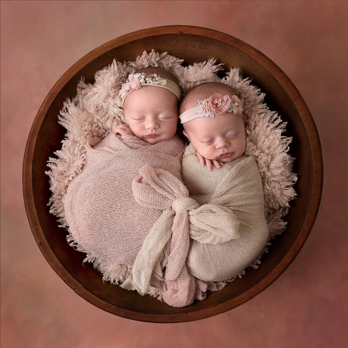 Sweet newborn twin in a pink Furry bowl