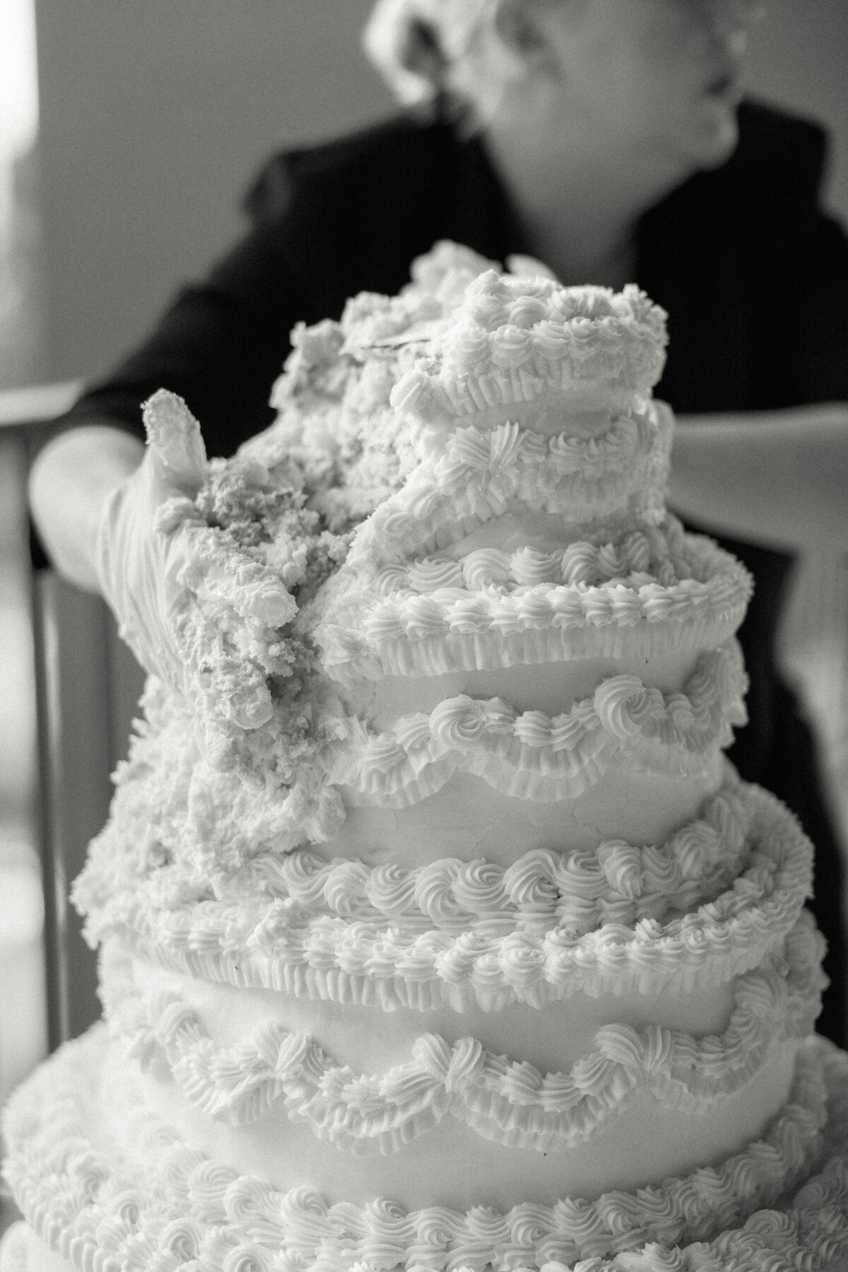 worker golding wedding cake together as it melts