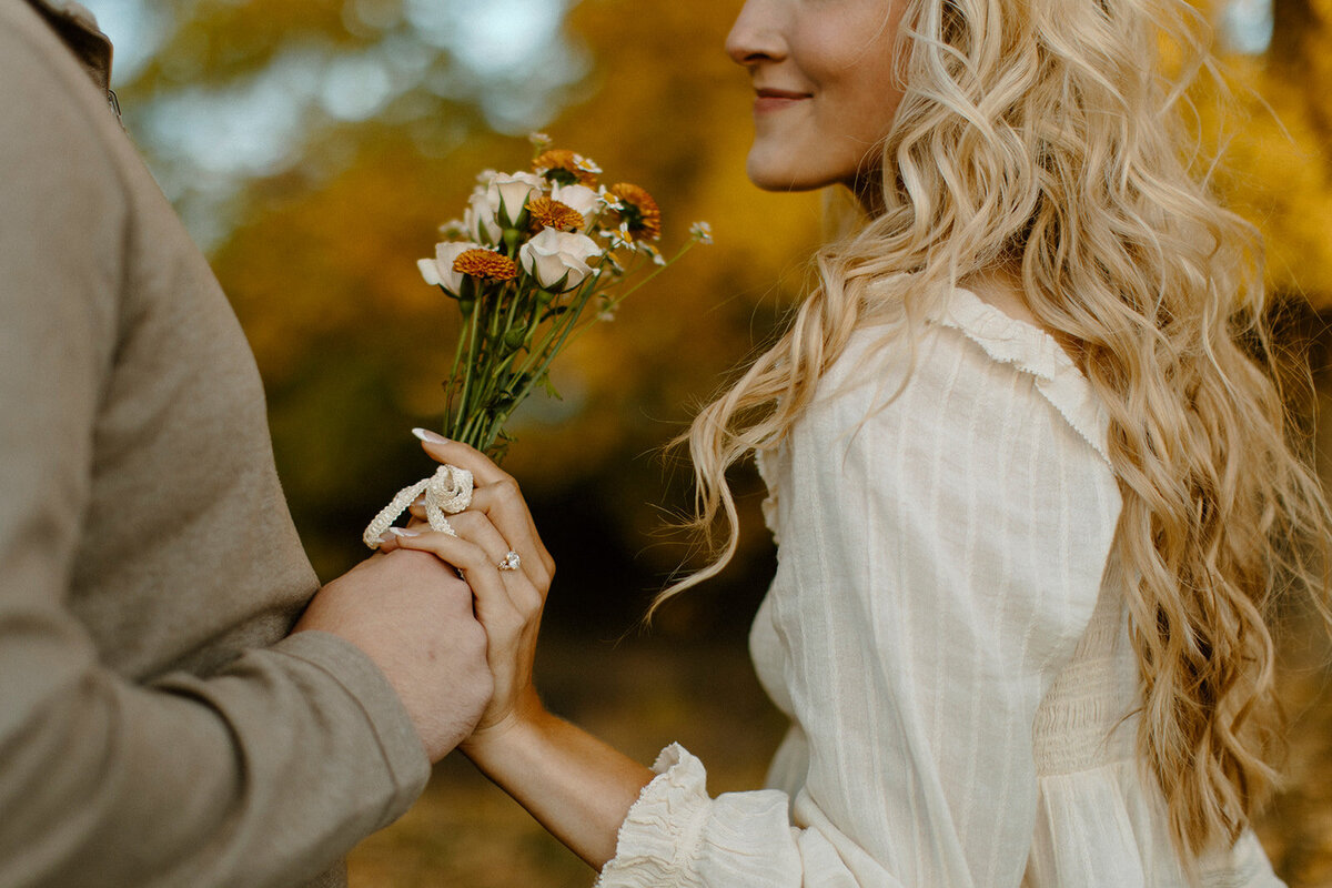 a man handing his fiance a bouquet of wildflowers