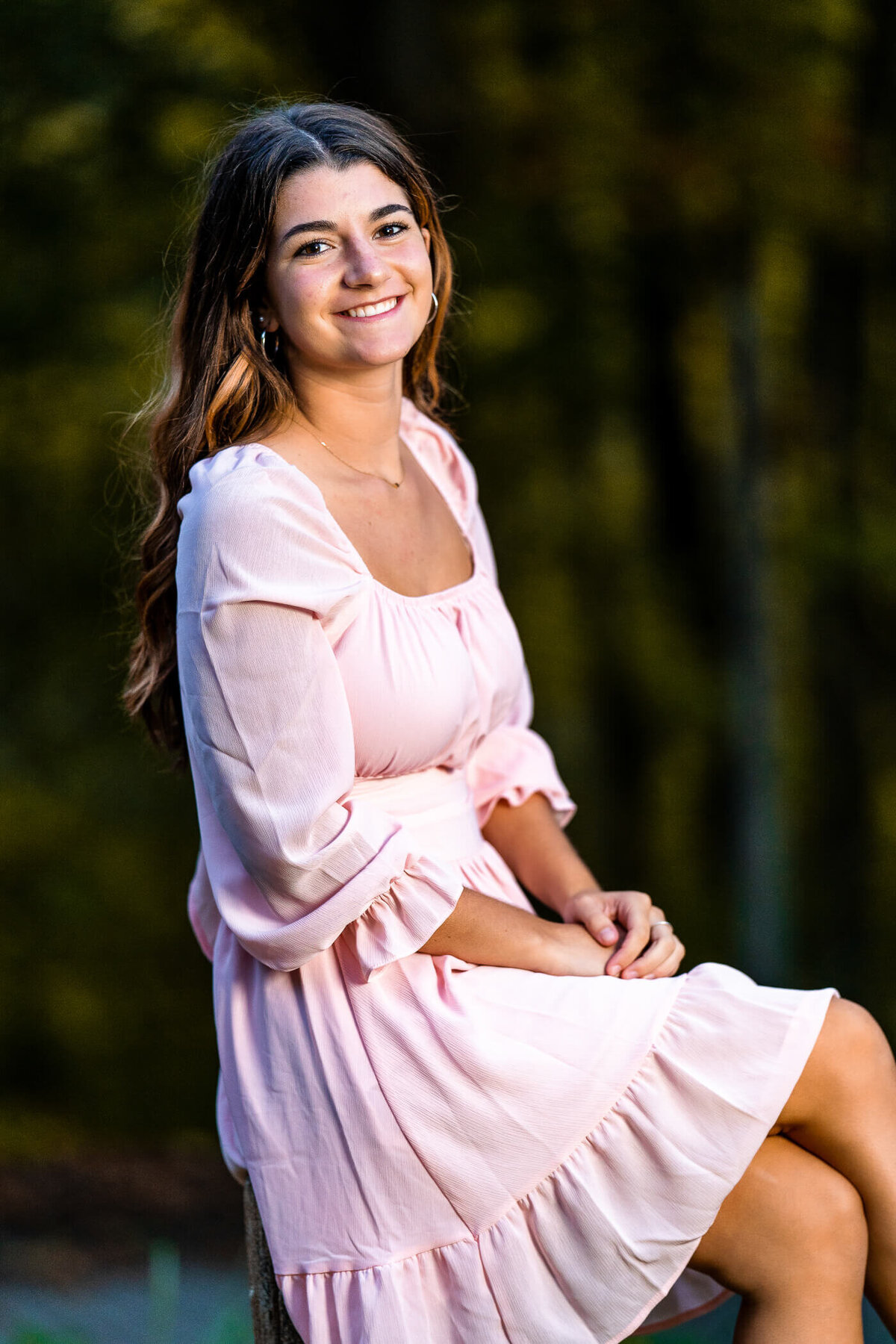 Senior photography of a senior sitting on a fence post at a state park near Pittsburgh PA
