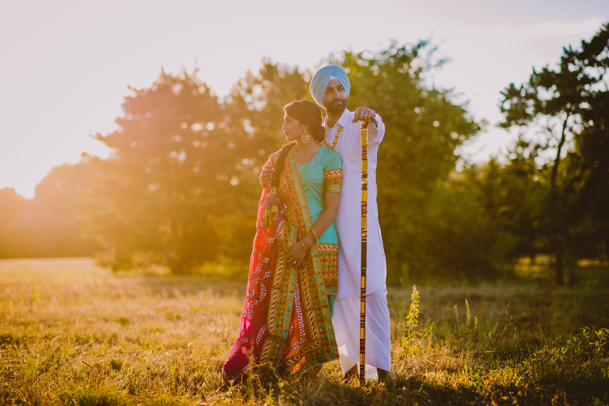 An engaged couple at an open field in traditional Punjabi clothing