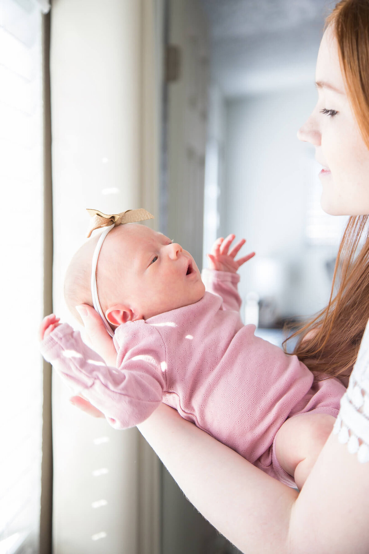 Newborn baby girl looking at mother