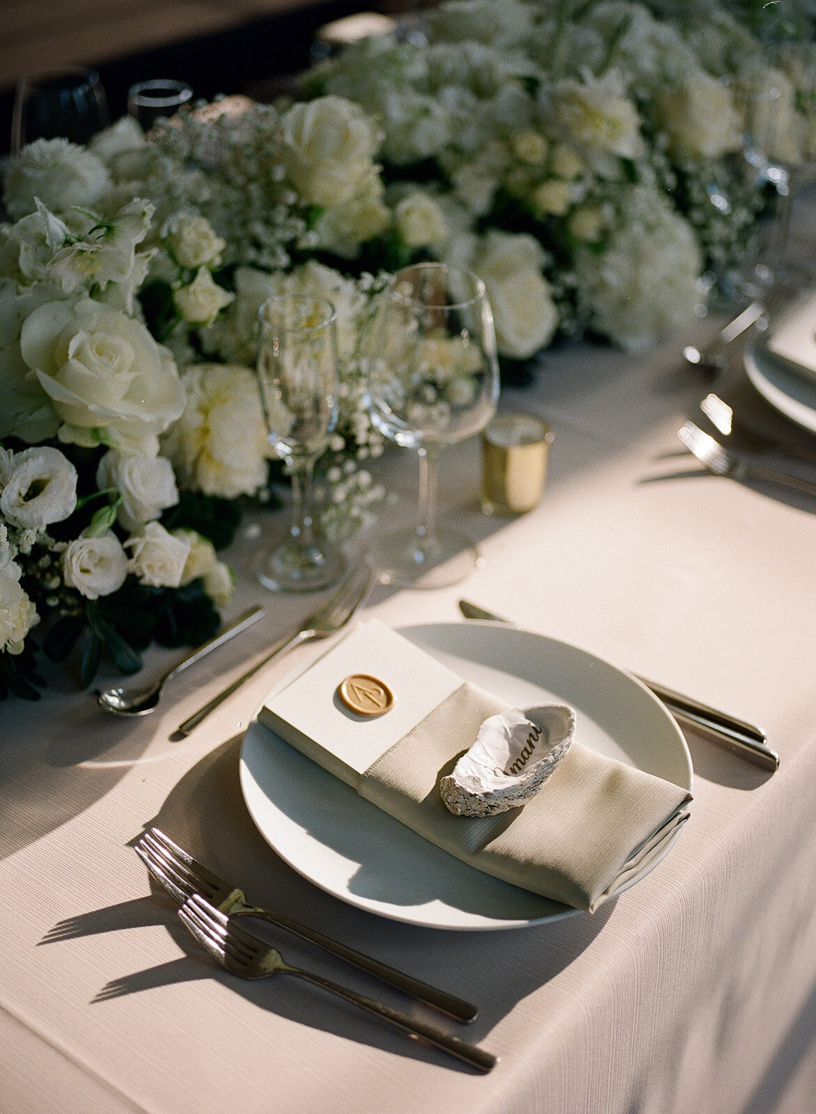 Elegant wedding table with white roses and oyster place cards