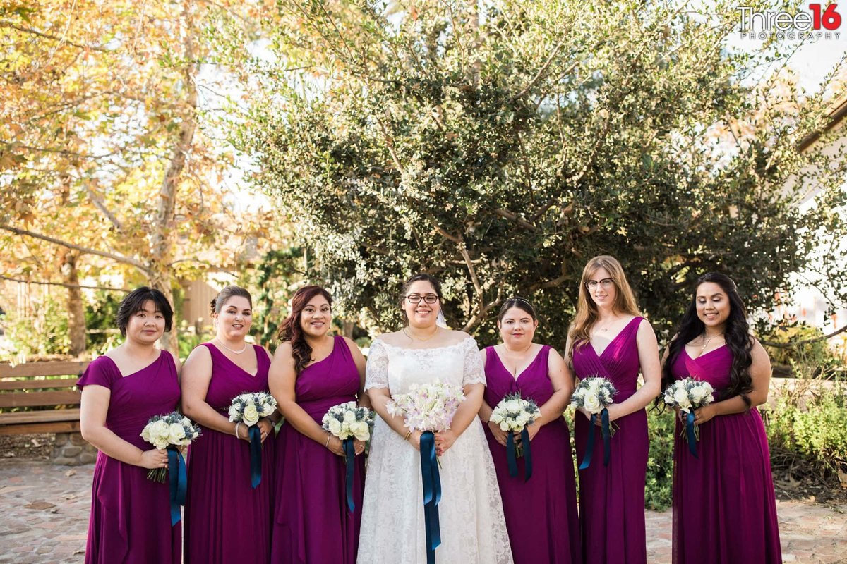 Bride posing with her Bridesmaids dressed in purple dresses
