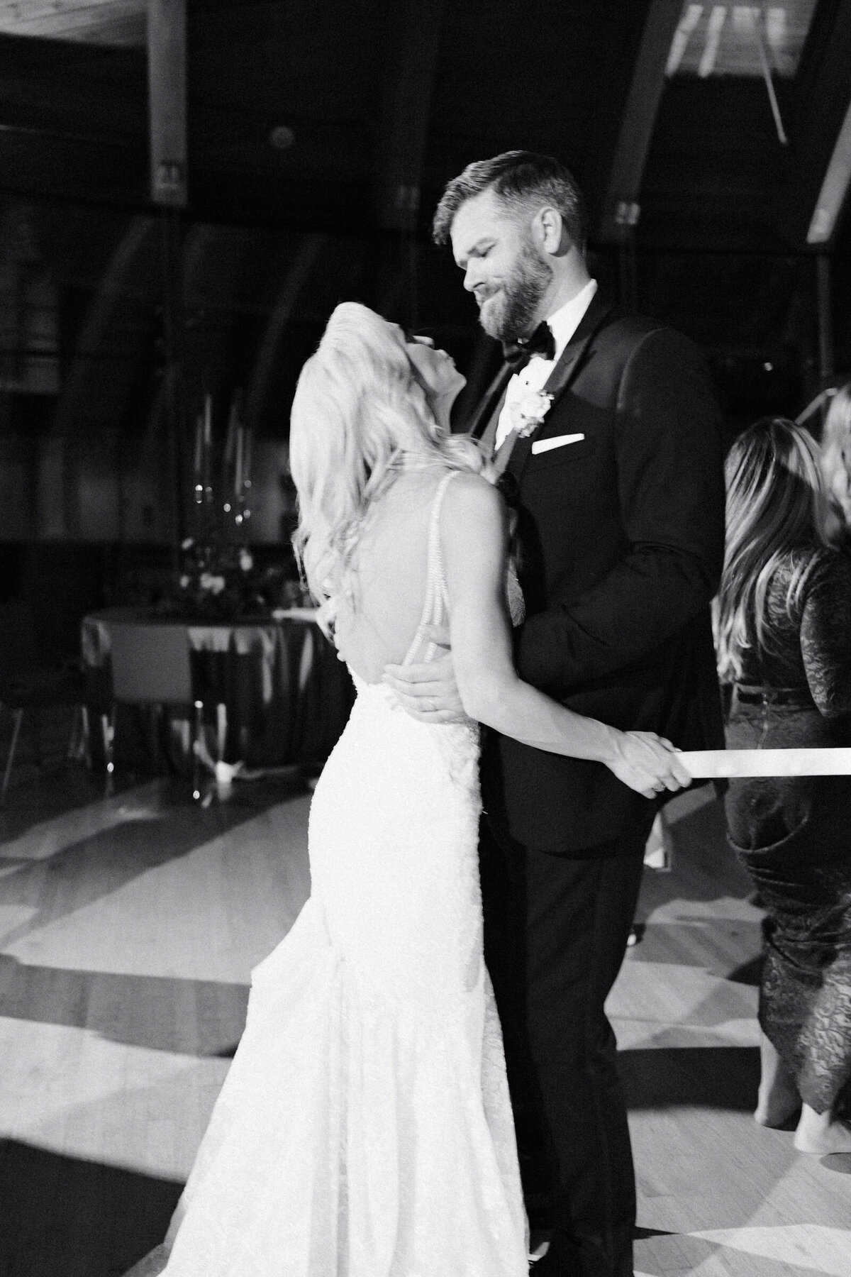 A candid black and white wedding photo of the bride and groom dancing at their reception at Crystal Bridges Museum of American Art