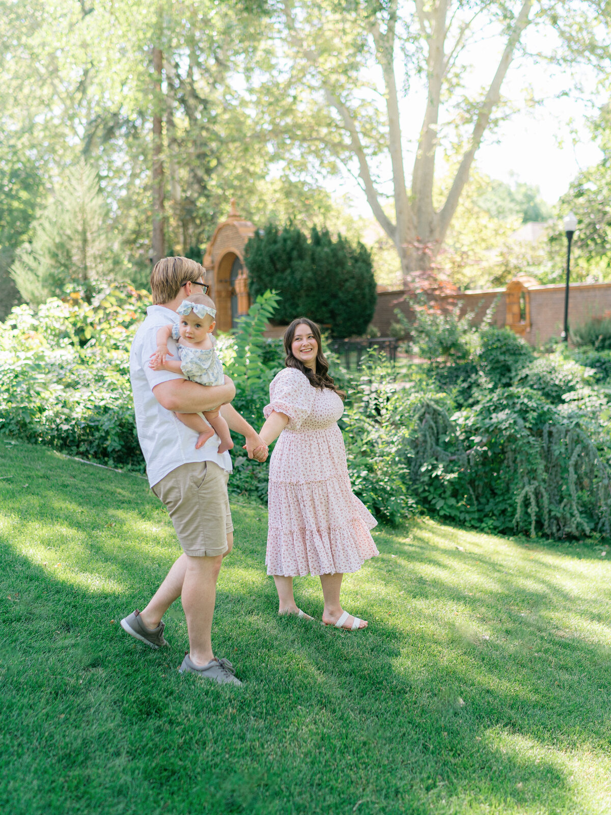 parents walking with baby in garden