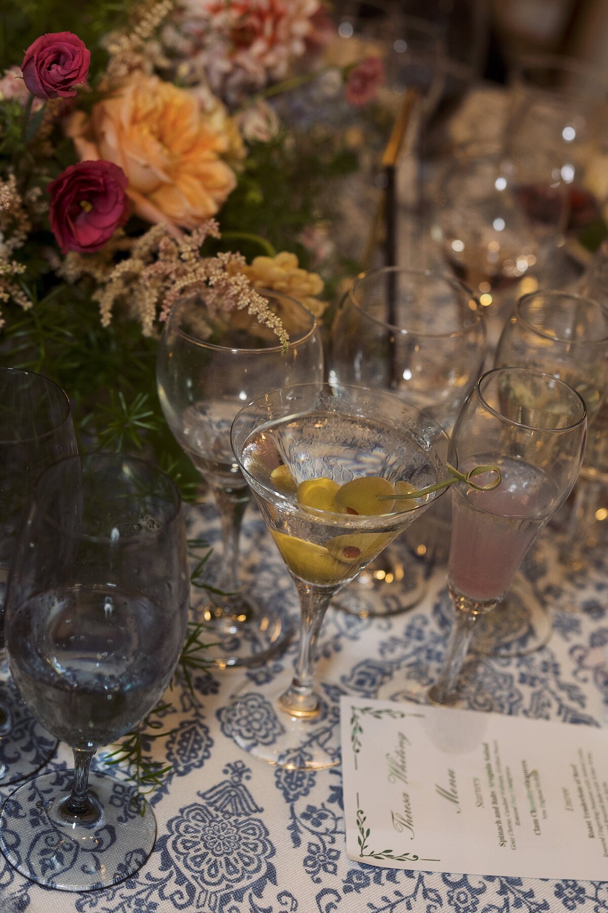 A martini with olives on table of wedding reception during Corinthian Yacht club wedding.