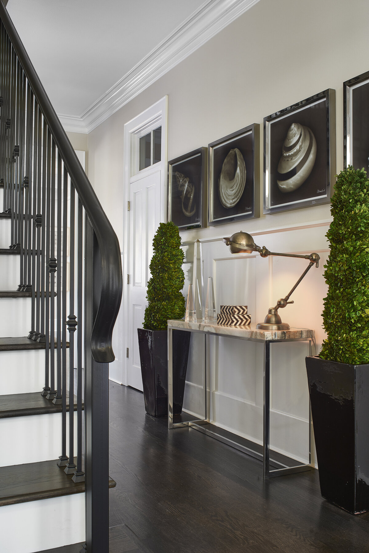 Foyer and Black Staircase + Hallway Dresser with Wall Portraits