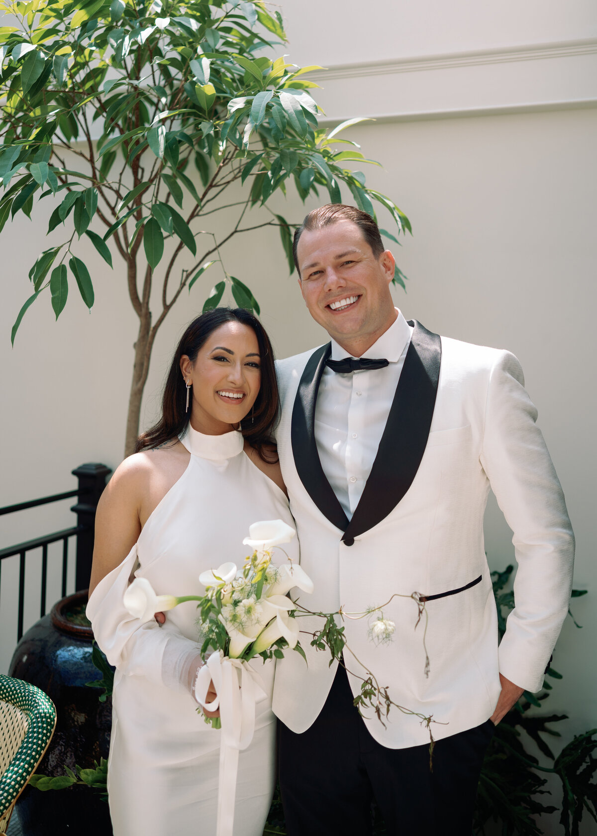 Bride and groom smiling together outdoors at Hotel Chelsea in New York City, captured during Japna and Chris’s intimate elopement by NYC wedding photographer Perry Hancock.