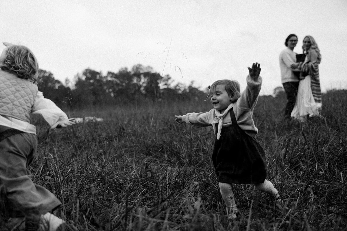 Little girls running and playing in a field during a family session in Atlanta, Georgia