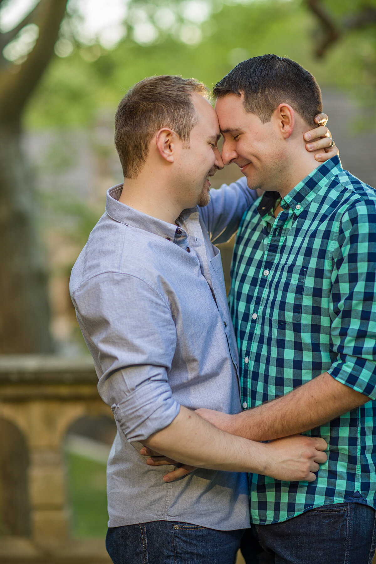 A heartfelt moment of a same-sex couple lovingly embracing during an engagement session at Ridley Creek State Park, surrounded by serene natural beauty that highlights their connection and joy.