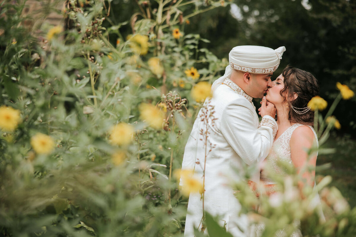 The bride and groom share an intimate moment embraced by the beautiful florals of Bartram's garden in Philadelphia.