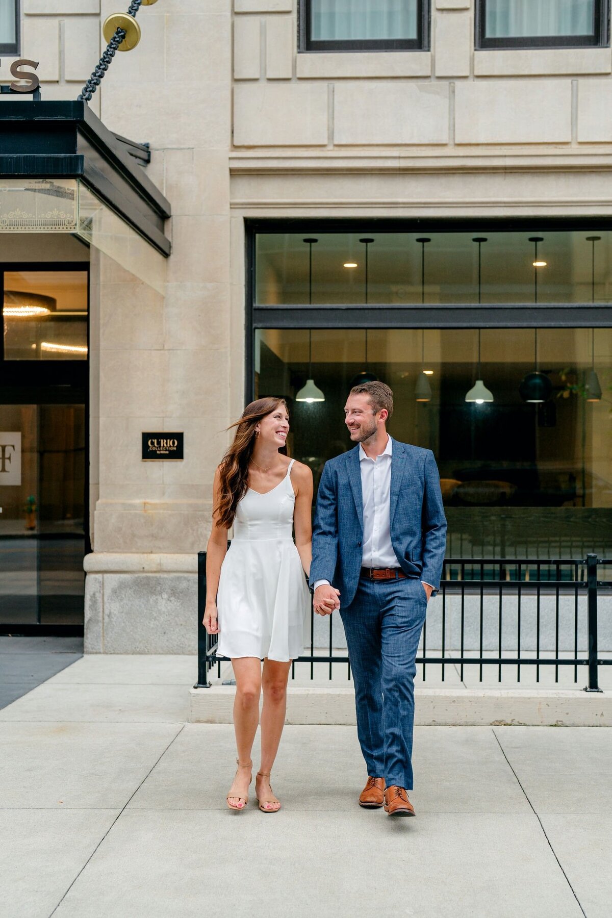 couple-walking-hand-in-hand-downtown-street-2