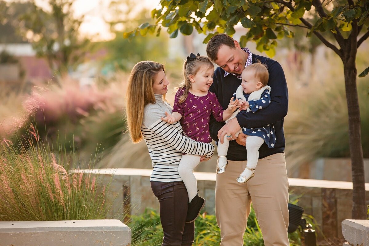 A family plays with their two children at a scenic location.